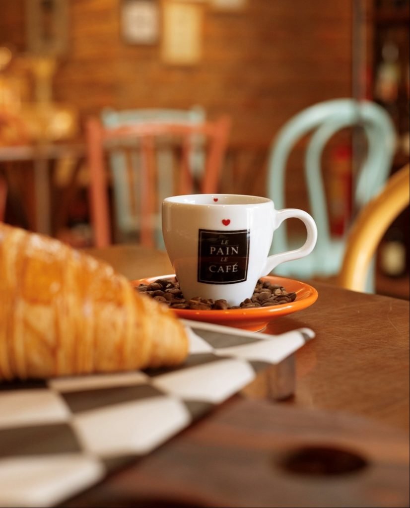 Mulher contente tomando café em uma cafeteria gourmet
